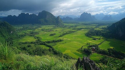 Obraz premium Stunning Panoramic View of Lush Green Valley Surrounded by Majestic Mountains in Laos