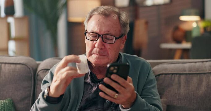 Senior man, phone and pills on sofa with search, online shopping or check label for product ingredients. Elderly person, smartphone and medicine with mobile app for order, info or benefits in home