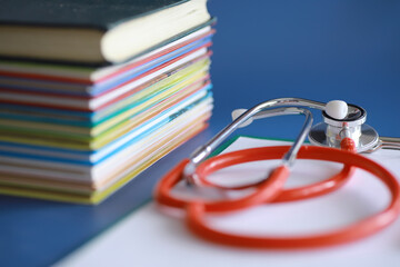 stethoscope on stack of medical guide book for doctor learning treatment at hospital.