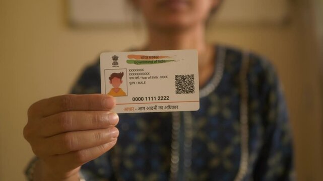 Indian woman holding Aadhaar card, closeup