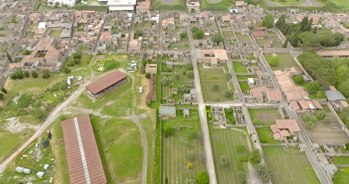 Aerial view of the ruins of houses and buildings of the ancient Roman city of Pompeii. The archaeological park is located in the province of Naples, Campania, Italy.