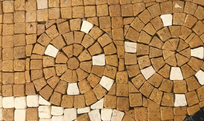 Fototapeta premium Detailed view of a mosaic stone wall with an intricate circular pattern.