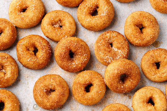 Mini cinnamon sugar donuts on baking paper.