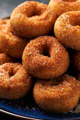 Mini cinnamon sugar donuts on blue plate