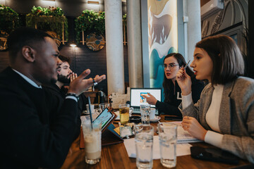 A group of diverse professionals collaborating on a project in a vibrant workspace. They focus on presentations and creative strategies while engaging in an inspiring team discussion around a table.