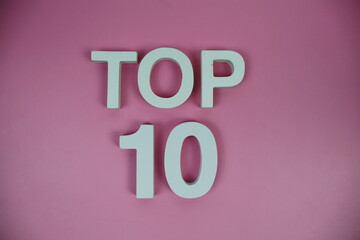 Top 10 alphabet letters top view on pink background