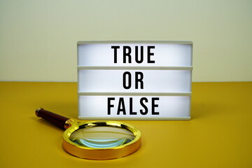 True or False text on light box with magnifying glass on yellow background