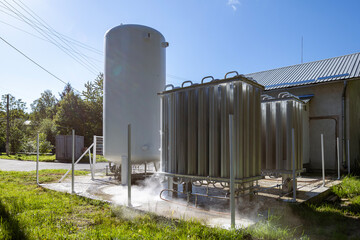 An oxygen station that produces and supplies medical oxygen to a hospital. The station includes radiators and a large white cylinder containing liquefied oxygen for distribution.