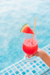Refreshing Watermelon Juice by the Poolside in Summer. Close-up of a Woman’s Hand Holding a Watermelon Punch
