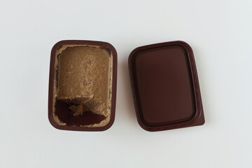 Liver pate in an open plastic package. Food tasting. White background.