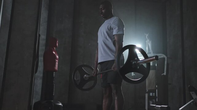 Fitness workout healthy lifestyle. African American man bodybuilder weightlifter picking up barbell doing heavy deadlifts in gym Weightlifting workout weight training muscles Man doing sports exercise