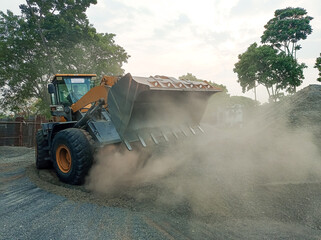 Loader operating on a construction site, raising dust