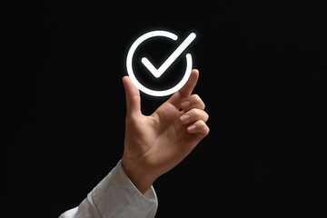 Approved. Woman holding virtual check mark in hand on black background, closeup