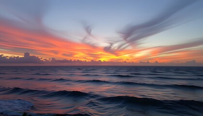 Obraz premium as the sun began to set, the distant view of the ocean transformed into a mesmerizing display of colors shades of orange, pink, and purple painting the water in a breathtaking panorama.