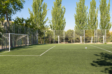 Soccer ball sitting on empty field on sunny day
