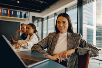 A confident and professional woman smiles brightly while actively participating in a dynamic...