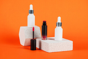 Mockup of black blank thin tube - mascara, lip gloss, gel, eyeliner, oil, etc. Cosmetic package with stylish props on orange background.