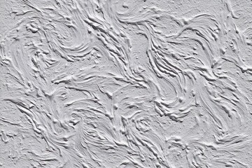 Fototapeta premium Textured, light gray plaster wall with swirling patterns