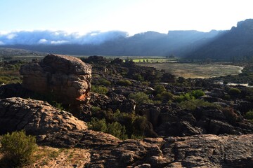 Expansive view of Pakhuis pass mountain landscape featuring rugged cliffs, rocky formations, and green vegetation
