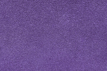 Grainy texture of asphalt, plaster, cement, plastic, rock, stone close up, macro. Background of purple colored granular wall surface, rough backdrop