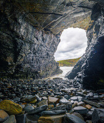 Coastal cave full of wave polished boulders