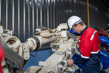 male engineer workers maintenance automatic robotic arm machine in a factory. worker checking and repairing automatic robot hand machine. technician worker check for repair factory machine.