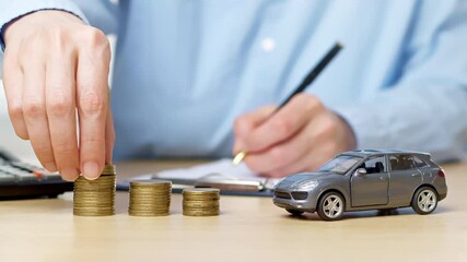 Concept of buying a car on credit, insurance. Hand stacking coins as accumulation of money.