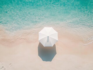 Serene top down view of white beach umbrella on sandy shoreline by turquoise sea