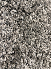 Closeup abstract grey beige fluffy fur fabric carpet texture background.Selective focus.