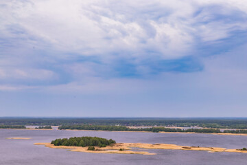 small islands on a wide river and lots of sky with beautiful clouds