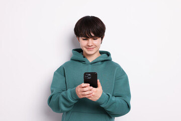 Teenage boy with smartphone on white background