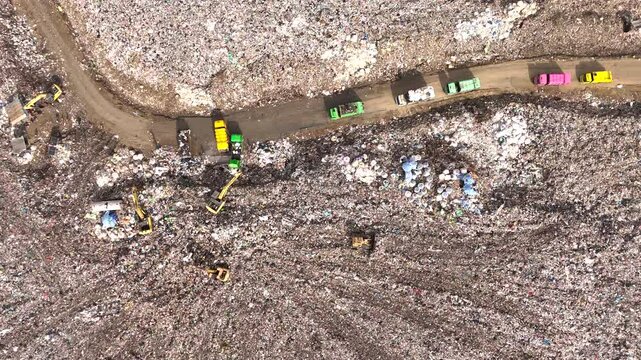 VDO 4K The truck is collecting garbage in a large garbage pile.