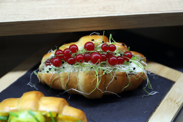 cruasán relleno de ensaladilla, grosellas y brotes germinados