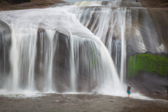 The grand beauty and fun water play and slides of Tham Phra Waterfall in the rainy season, Bueng Kan province Thailand
