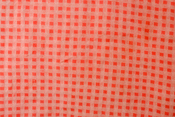 A red and white checkered fabric with a pattern of squares