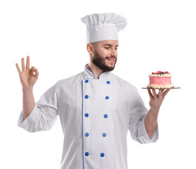 Happy confectioner in uniform holding delicious cake with berries and showing ok gesture on white background