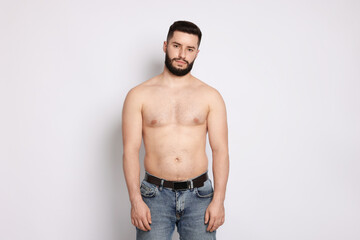 Fototapeta premium Man after weight loss on light background