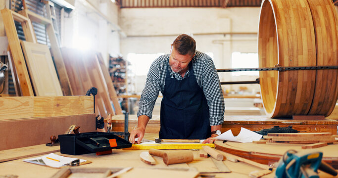 Carpentry, industry and planning with man in workshop for manufacturing or production process. Creative, design and documents with carpenter in woodworking studio for craftsmanship or manual labor
