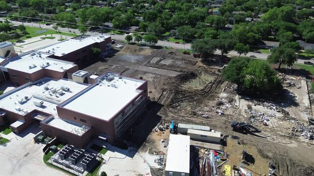 Bitumen roof system with commercial HVAC units of elementary school under remodel construction site preparation, paving, utilities storm drainage system install, demolition, Marcus Park, Dallas