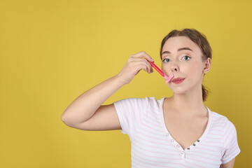 Beautiful woman shaving her mustache with razor on light green background. Space for text