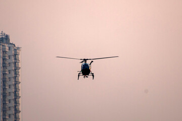 Helicopter is flying away on isolated dawn sky