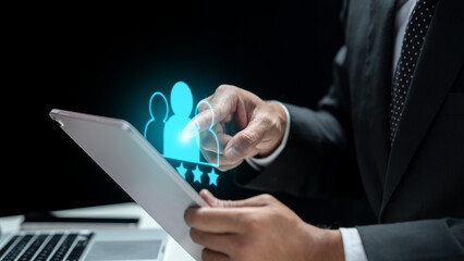 Businessman holding a tablet while touching the icon of a human representing the customer. Technology innovation on a virtual screen. Concept of Client or Customer