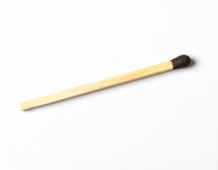 Obraz premium A single, unused matchstick rests on a clean white surface, ready to strike and ignite
