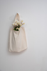 wildflowers in a reusable cloth vintage bag on a white background. Eco-friendly and natural....