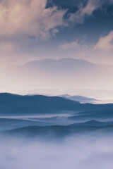 fantasy landscape with hills and mountain in fog