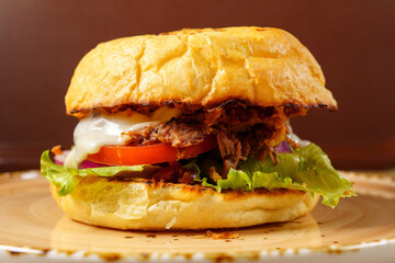 Delicious pulled pork sandwich served with fresh vegetables and creamy sauce on a toasted bun