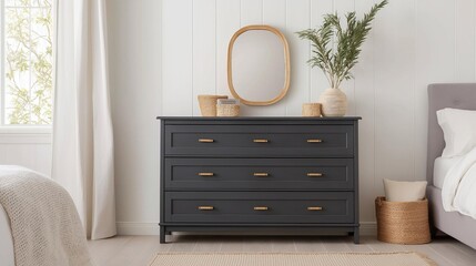 Modern bedroom with a black wooden dresser in the center. the dresser has six drawers with gold handles and is placed against a white wall.