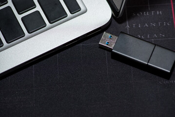 Hand inserting Flash drive memory drive plugged into a computer laptop port.