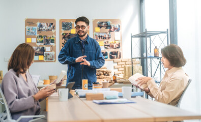 Obraz premium Business asian people working together in an ESG office reduce cost package price by recycle material