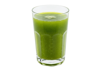 Refreshing green smoothie in a clear glass against a black background